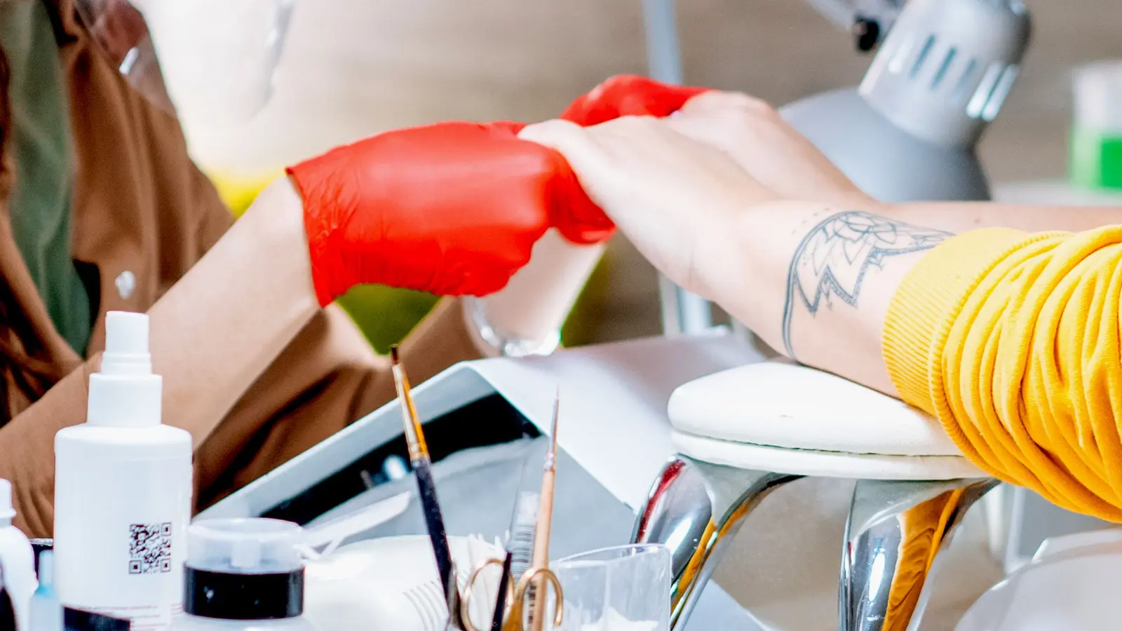 Nageltekniker som håller kundens händer under en manikyr